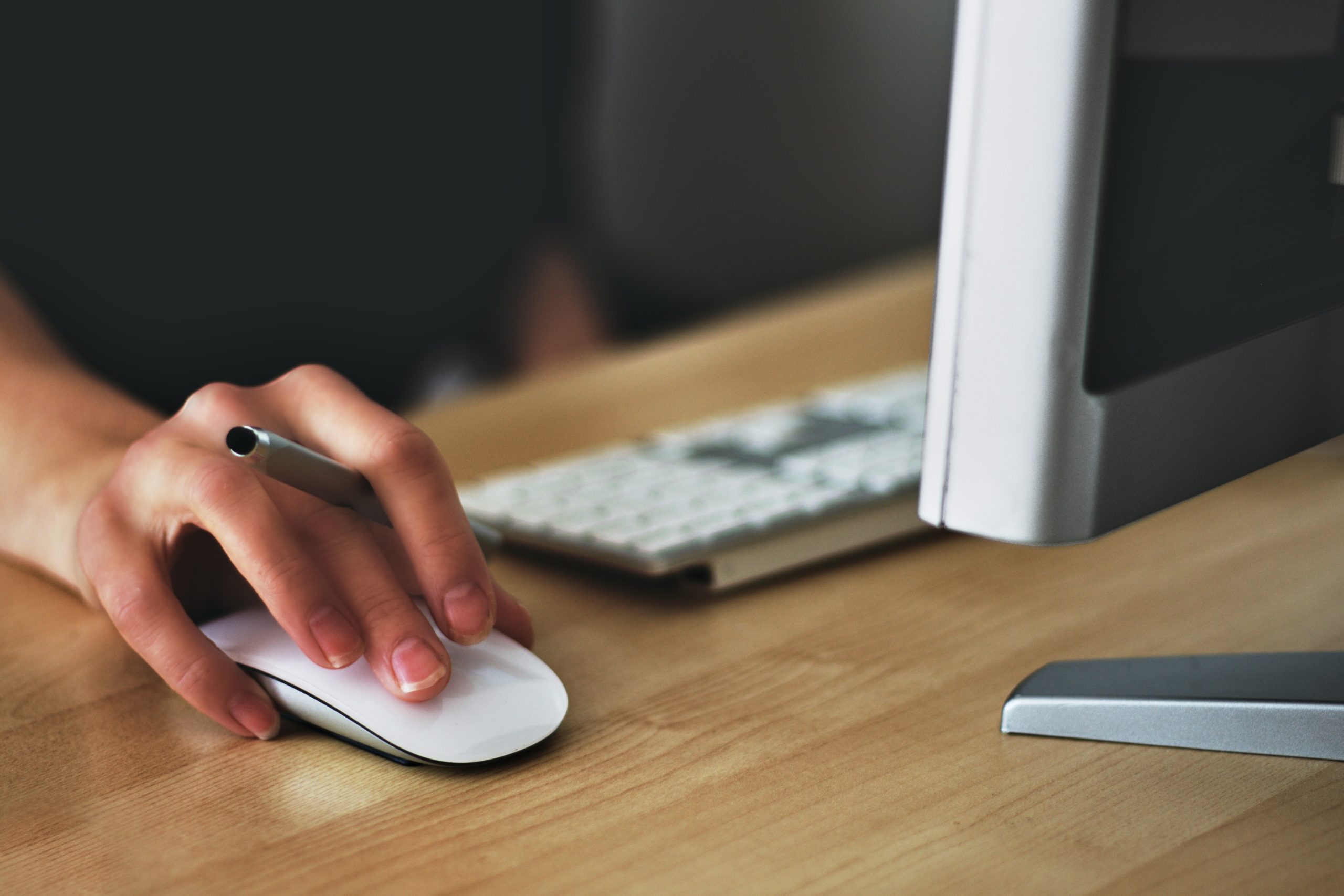 someone sat in front of a computer, using the mouse