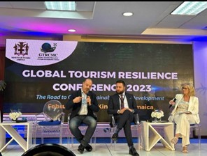 three people on stage at conference discussing the tourism industry's resilience